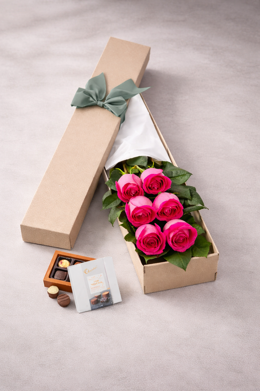 Gift box with pink roses and chocolates on a light gray background